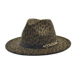 Détail du chapeau fedora à imprimé léopard avec bande en cuir noir et chaîne dorée