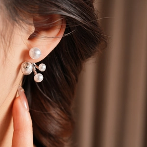 Close-up of cluster pearl earrings with zircon detail on model ear for luxury look