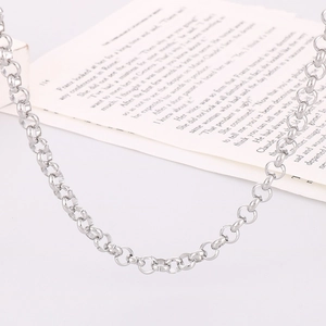 Minimalist silver stainless steel round link necklace on an aesthetic book background