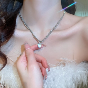 Close-up of sparkling multi-layer zircon bow heart necklace on a model collarbone