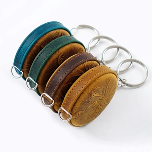 Detailed view of four retro crazy horse leather mini tape measures with embossed patterns