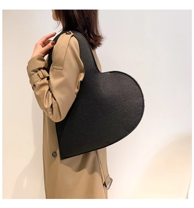 Fashionable black heart-shaped felt handbag shown on a model in a minimal setting