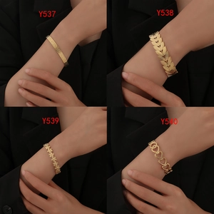 Detail view of four gold-plated bangle styles including heart and leaf patterns