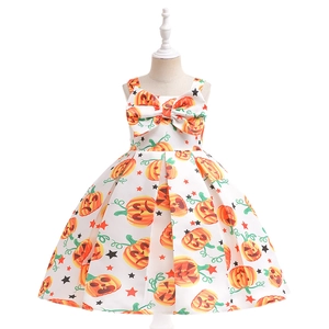Close-up of girls Halloween dress featuring orange pumpkin patterns and a large bow