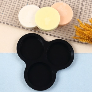 Detail of 3-cavity black silicone mold with finished colorful handmade round soaps