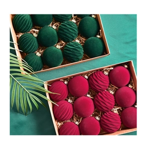 Detailed view of 6cm burgundy and dark green velvet Christmas balls in a gift box