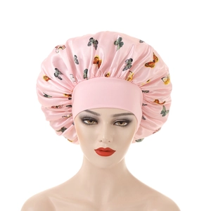 Detail of pink satin sleep bonnet featuring colorful butterfly prints and elastic wide band