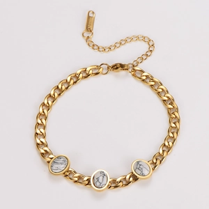 Detailed macro view of gold stainless steel bracelet with oval white turquoise stones