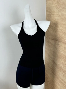 Close-up of black ribbed deep V-neck crop top fabric texture on a white mannequin