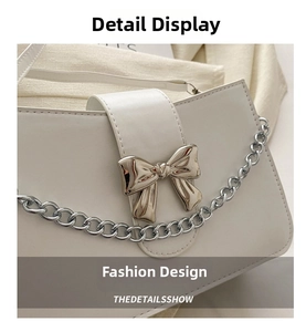 Detailed view of silver bow-shaped metallic buckle on beige leather crossbody bag