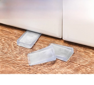 Close-up of transparent non-slip wedge shims for leveling furniture on wooden floors