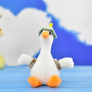 Détail d'un mignon porte-clés en peluche d'oie blanche portant un petit chapeau vert déco