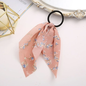 Detailed shot of pink floral chiffon ribbon hair tie on a minimalist decorative desk