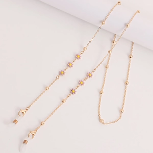 Detail of gold eyewear chain featuring purple enamel daisies and white silicone loops