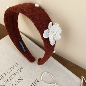 Detailed macro view of handmade maroon velvet headband with white pearl flower decoration