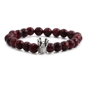 8mm dark red spotted stone beaded bracelet with silver crown charm on white background