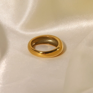 Polished 18k gold plated round ring displayed on elegant beige silk background