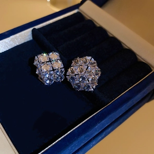 Macro view of geometric cubic zirconia earrings with faceted crystal in a velvet gift box