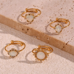 Detail of adjustable 18K gold plated rings with white opal heart and floral designs