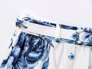 Detail of elastic waist with blue floral print and white buckle belt on skirt