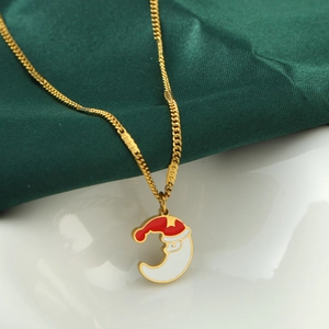 Golden crescent moon necklace with Santa Claus enamel pendant on green fabric background