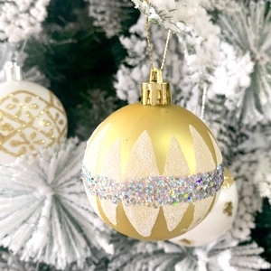 Dettaglio pallina di Natale oro opaco e bianco con fascia di glitter argento