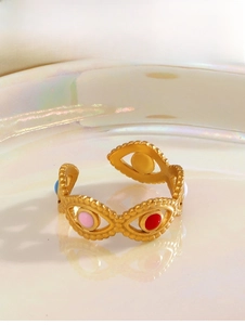 Detail of adjustable golden ring featuring colorful enamel evil eye charms on a tray
