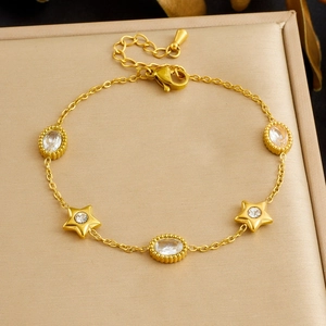 Detail of gold plated stainless steel bracelet with star charms and oval crystal stones