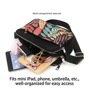 Black floral oxford crossbody bag with multiple zip pockets showing high storage capacity