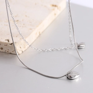 Dettaglio della collana a doppio strato in argento con pendenti a cuore e catene a serpente