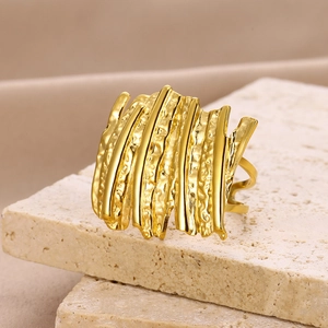 Detail of golden wide open ring with irregular vertical bars and hammered texture surface