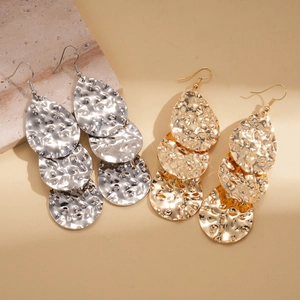 Détail des boucles d'oreilles en cascade avec texture métallique martelée or et argentée