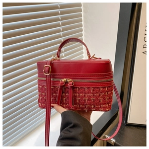 Detail view of red tweed and leather crossbody box bag with golden double zippers