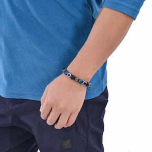 Dettaglio macro del bracciale di perle di occhio di tigre e ossidiana con ciondolo occhio