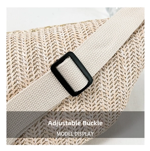 Detail of straw woven waist bag showing the cream color fabric and adjustable buckle