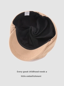 Detail of beige beret hat showing black inner lining with elastic band and size label