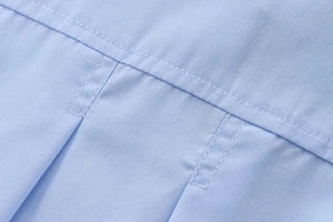 Détail rapproché des coutures et du tissu en coton d'une chemise bleue pour femme