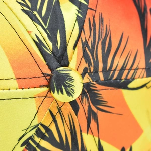 Macro shot of tropical palm leaf print and fine stitching on a satin baseball cap