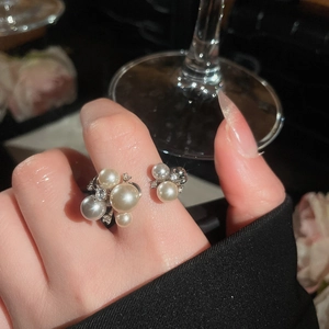 Macro shot of a vintage pearl ring with zircon accents on a hand in elegant setting