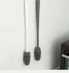 Detail showing hanging long handle silicone cleaning brushes with dense grey bristles