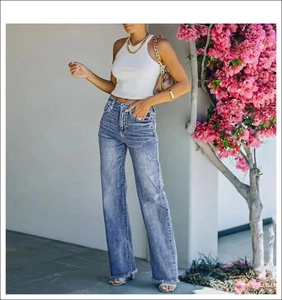 Detailed texture of heavy-washed denim fabric on distressed wide-leg jeans for women