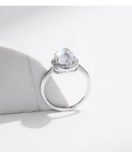 Macro shot of S925 silver ring featuring round cabochon moonstone with diamond halo