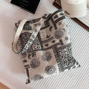 Detailed top view of paisley print canvas tote bag with book and baseball cap