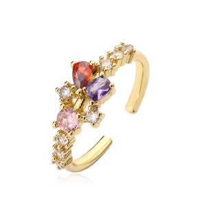 Gold-plated open ring with pear-shaped red zircon and colorful gemstones on white background