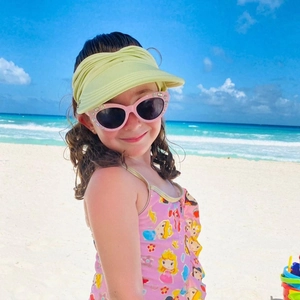 Detail of toddler summer beach set with a wide brim sun hat and Disney princess swimsuit