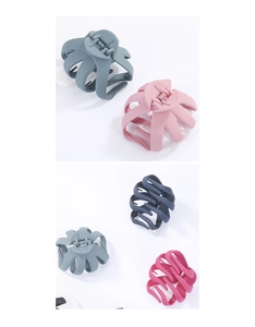 Varie pinze per capelli in colori pastello opachi su uno sfondo bianco pulito