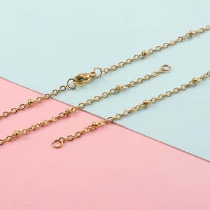304 stainless steel cross bead chain necklace in golden finish on dual-tone background