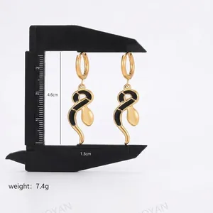 Elegant gold and black snake-shaped drop earrings featuring enamel finish and teardrop charm