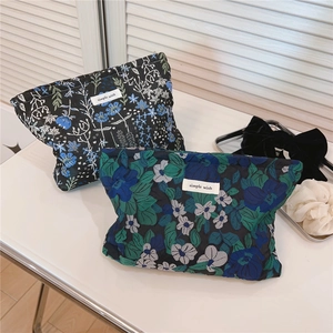 Detailed macro view of quilted floral canvas makeup bags with 'Simple Wish' label