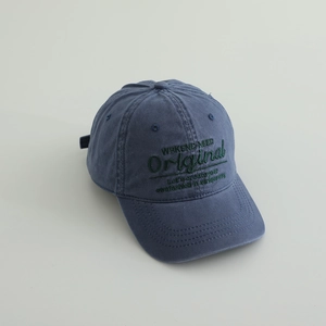 Dettaglio del berretto da baseball in denim lavato blu navy con ricami verdi moda